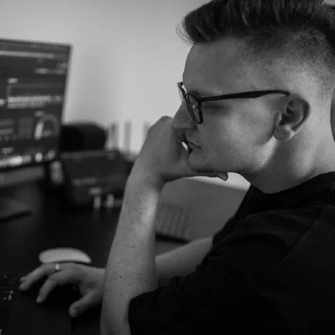 Me at my desk, a monitoring dashboard on the screen beside me