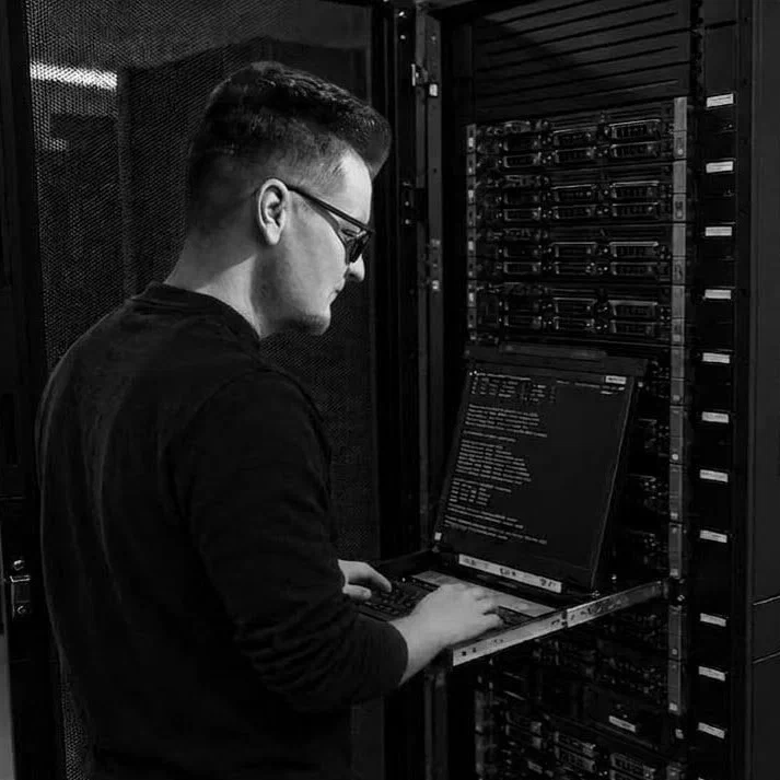Me at a server rack in a data centre, typing on the rack's pull-out console