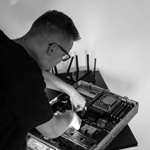 Me leaning over an opened rack server with the lid off, seating a component on the board